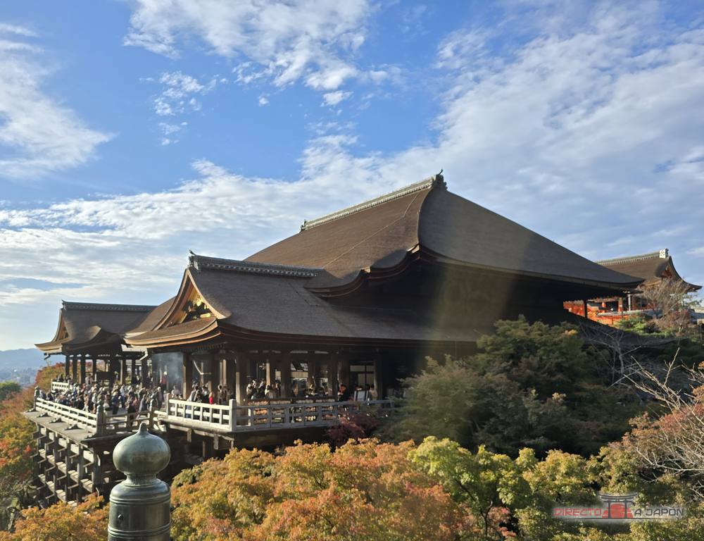 Salón principal Hondo de Kiyomizudera con su escenario de madera sobre la ladera y arces con colores de otoño.
