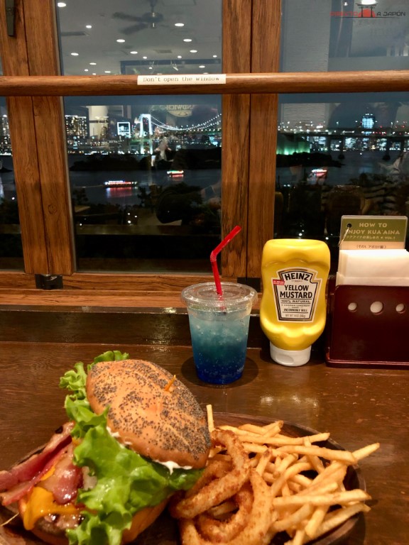 Comienndo una hamburguesa en Kua Aina con vistas a la bahía de Tokio